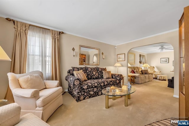 carpeted living room with crown molding and ceiling fan