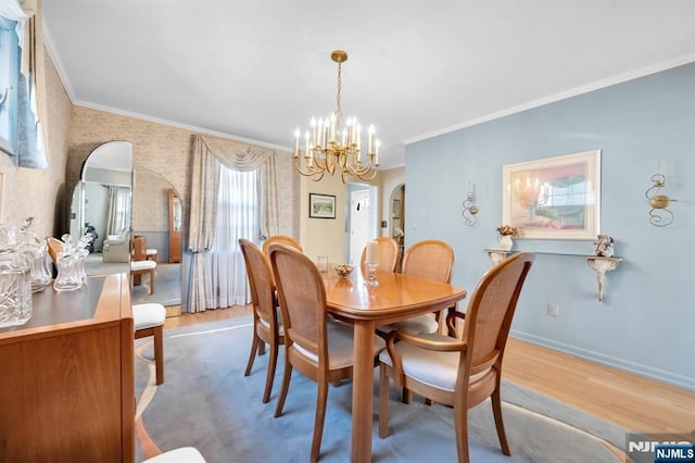 dining room featuring an inviting chandelier, crown molding, and light wood-type flooring