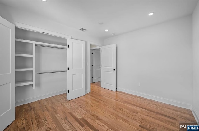 unfurnished bedroom featuring a closet and light hardwood / wood-style flooring