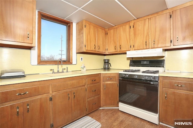 kitchen featuring sink, white range with gas stovetop, and light wood-type flooring