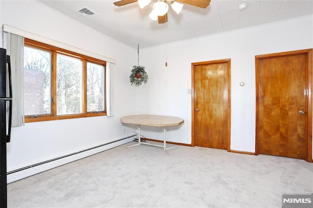 carpeted empty room with crown molding, ceiling fan, and baseboard heating