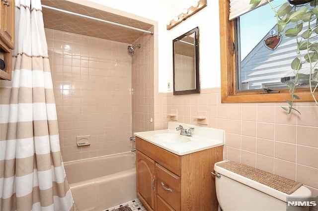 full bathroom with shower / bath combo with shower curtain, vanity, toilet, and tile walls