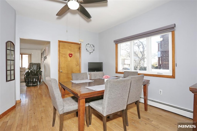 dining area featuring a baseboard heating unit, light hardwood / wood-style flooring, a healthy amount of sunlight, and ceiling fan