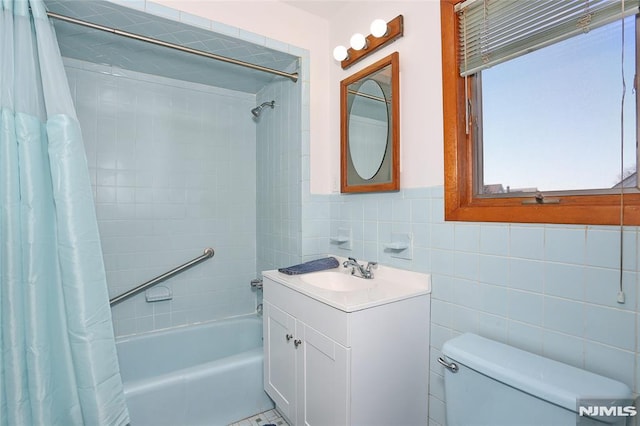 full bathroom with toilet, tile walls, vanity, and shower / bath combo with shower curtain