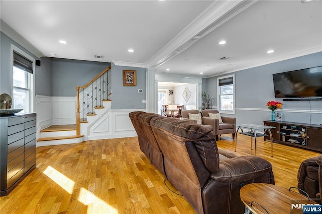 living room with crown molding and light wood-type flooring