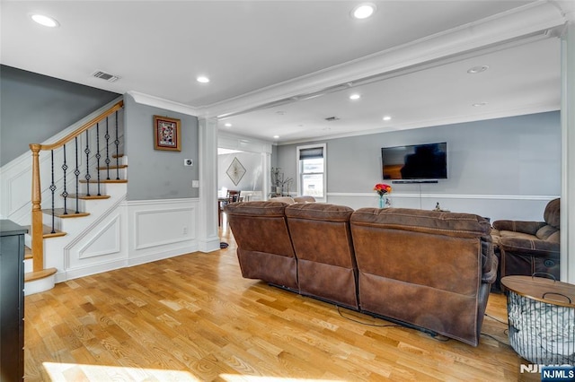 living room featuring crown molding and light hardwood / wood-style flooring