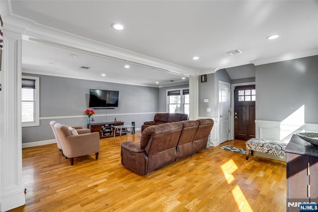 living room with crown molding and light hardwood / wood-style floors