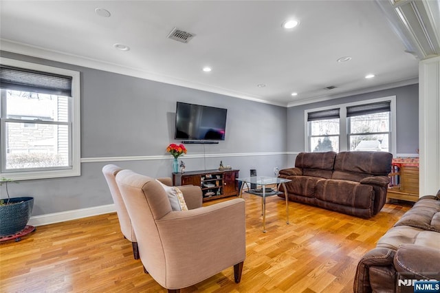 living room with ornamental molding, a healthy amount of sunlight, and light hardwood / wood-style floors