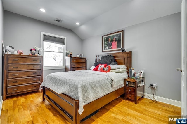 bedroom with vaulted ceiling and light hardwood / wood-style flooring