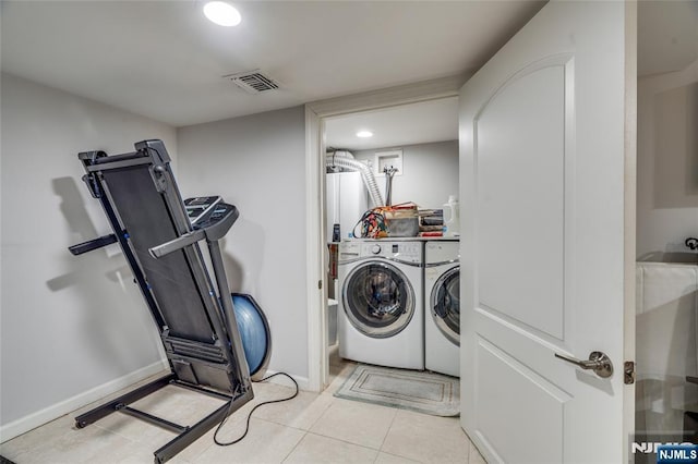 clothes washing area featuring light tile patterned flooring and independent washer and dryer