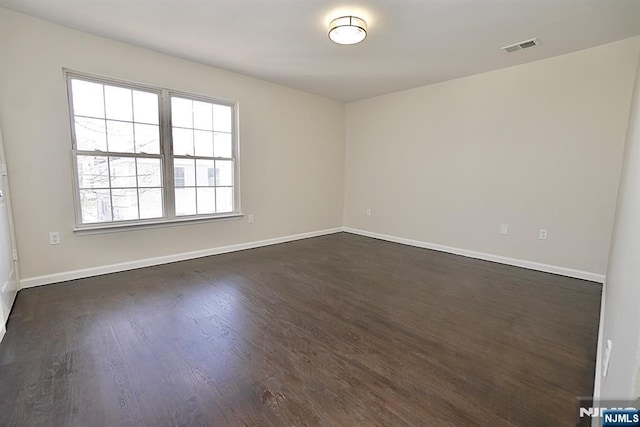 spare room featuring dark wood-type flooring