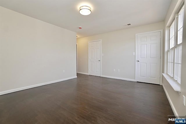 unfurnished room with dark hardwood / wood-style flooring