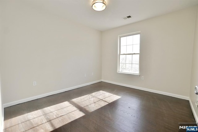 empty room featuring dark hardwood / wood-style flooring