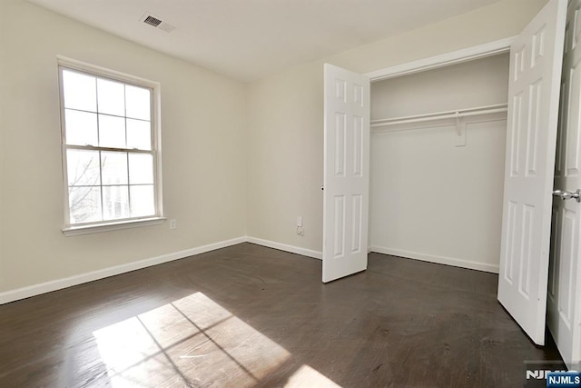 unfurnished bedroom with dark hardwood / wood-style floors and a closet