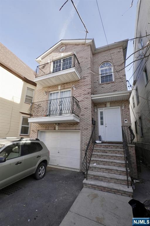 view of property featuring a garage and a balcony