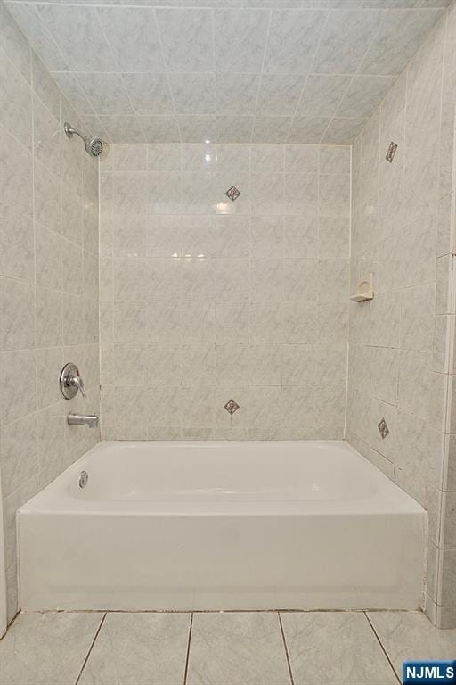 bathroom featuring tiled shower / bath combo and tile patterned floors