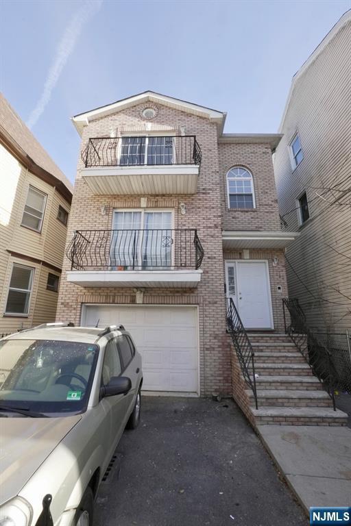 view of property with a balcony and a garage