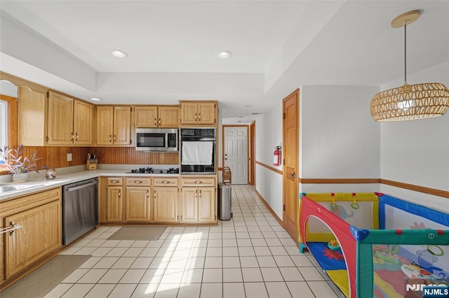 kitchen with hanging light fixtures, light tile patterned floors, and black appliances