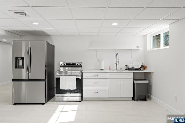 kitchen featuring appliances with stainless steel finishes, sink, a paneled ceiling, and white cabinets