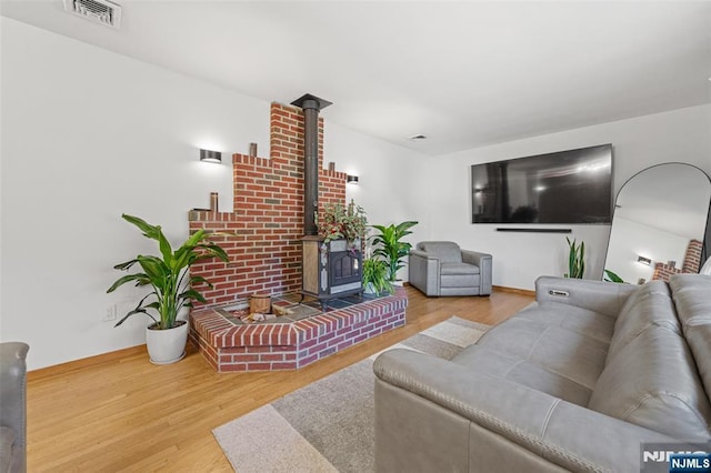 living room featuring wood-type flooring and a wood stove