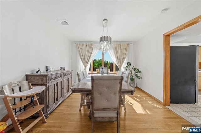 dining room featuring a chandelier and light wood-type flooring