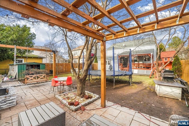 view of patio / terrace featuring a storage unit, a pergola, and a trampoline