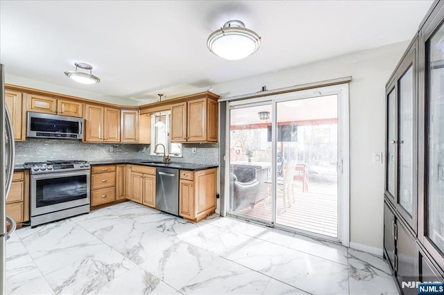 kitchen featuring tasteful backsplash, appliances with stainless steel finishes, and sink