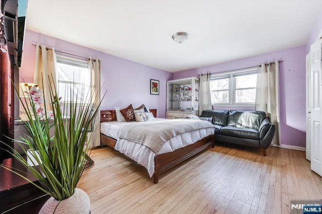 bedroom featuring multiple windows and light wood-type flooring