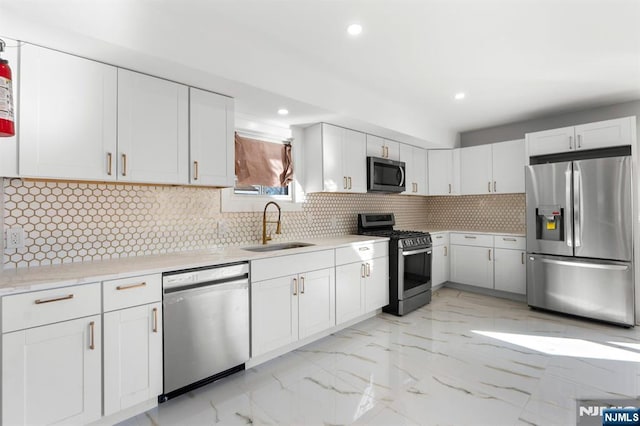 kitchen featuring white cabinetry, stainless steel appliances, sink, and backsplash