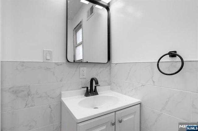 bathroom with vanity and tile walls