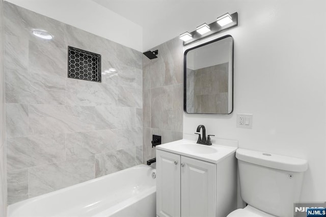 full bathroom with tiled shower / bath, vanity, and toilet