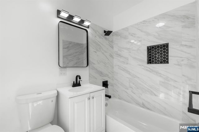 full bathroom featuring vanity, tiled shower / bath, and toilet