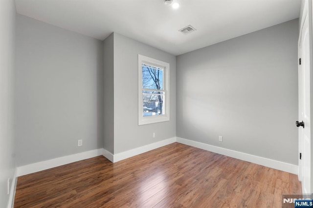 unfurnished room with hardwood / wood-style floors