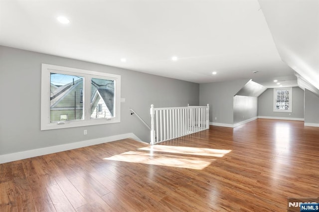 bonus room with wood-type flooring and vaulted ceiling