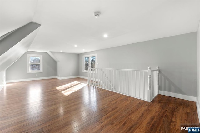 additional living space featuring wood-type flooring and vaulted ceiling