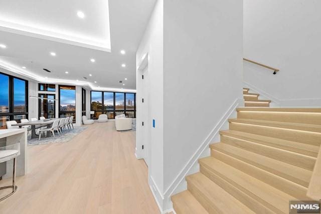 stairway featuring a wall of windows and hardwood / wood-style floors