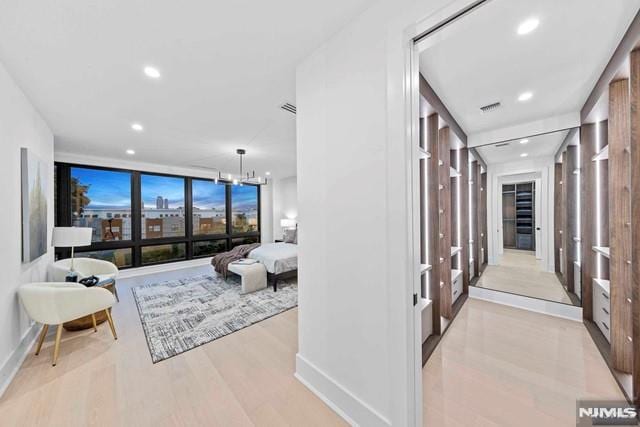 corridor featuring a chandelier and light hardwood / wood-style floors