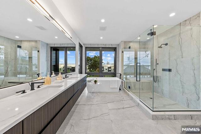 bathroom featuring vanity and independent shower and bath