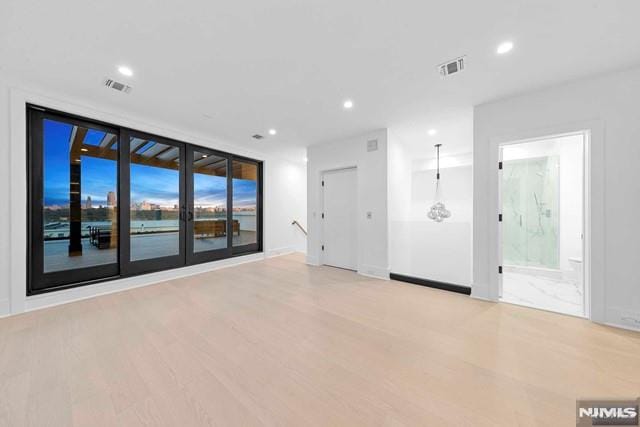 empty room featuring light hardwood / wood-style flooring and floor to ceiling windows