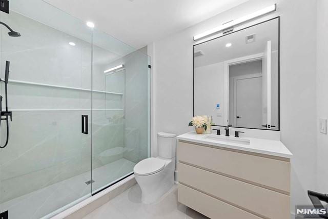 bathroom with vanity, toilet, and a shower with shower door