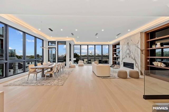 living room featuring hardwood / wood-style floors, a premium fireplace, built in features, and expansive windows