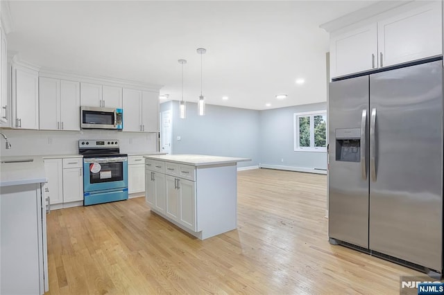 kitchen featuring pendant lighting, sink, white cabinets, a center island, and stainless steel appliances