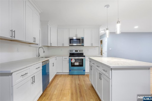 kitchen featuring sink, a kitchen island, white cabinets, and appliances with stainless steel finishes