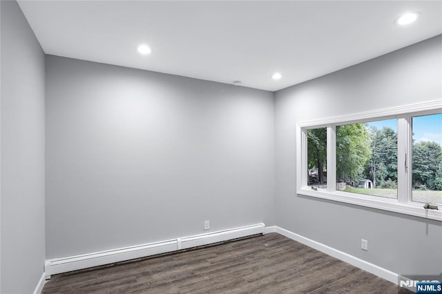 unfurnished room with a baseboard radiator and dark hardwood / wood-style floors