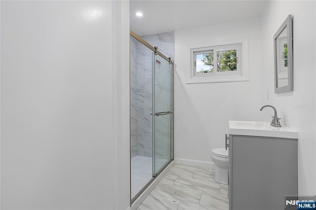 bathroom featuring a shower with door, vanity, and toilet