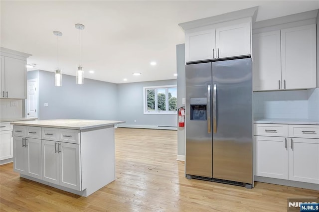 kitchen featuring white cabinetry, stainless steel refrigerator with ice dispenser, and decorative light fixtures