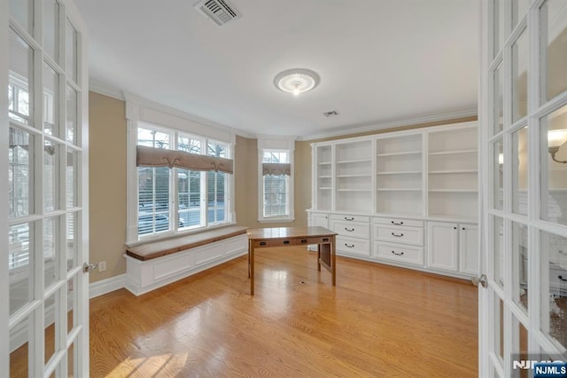 unfurnished office featuring ornamental molding, french doors, and light wood-type flooring