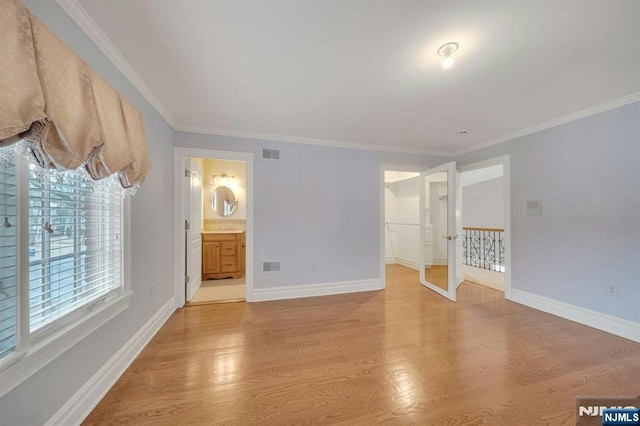 spare room with ornamental molding and light wood-type flooring