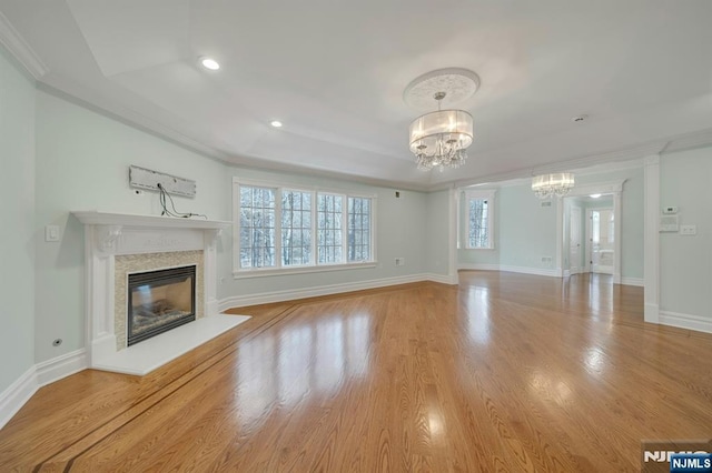 unfurnished living room with ornamental molding, light hardwood / wood-style floors, and a chandelier