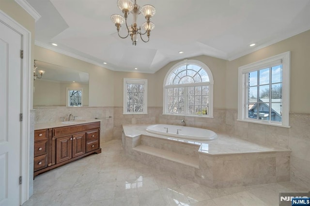 bathroom featuring tile walls, vanity, ornamental molding, tiled bath, and a chandelier